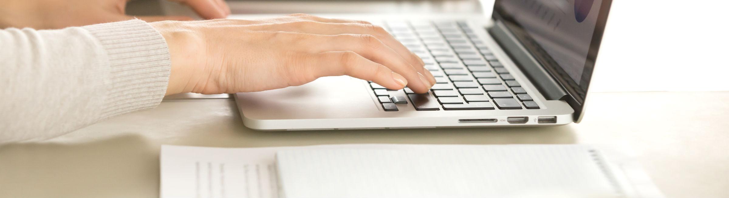 Une femme tape sur son clavier d'ordinateur